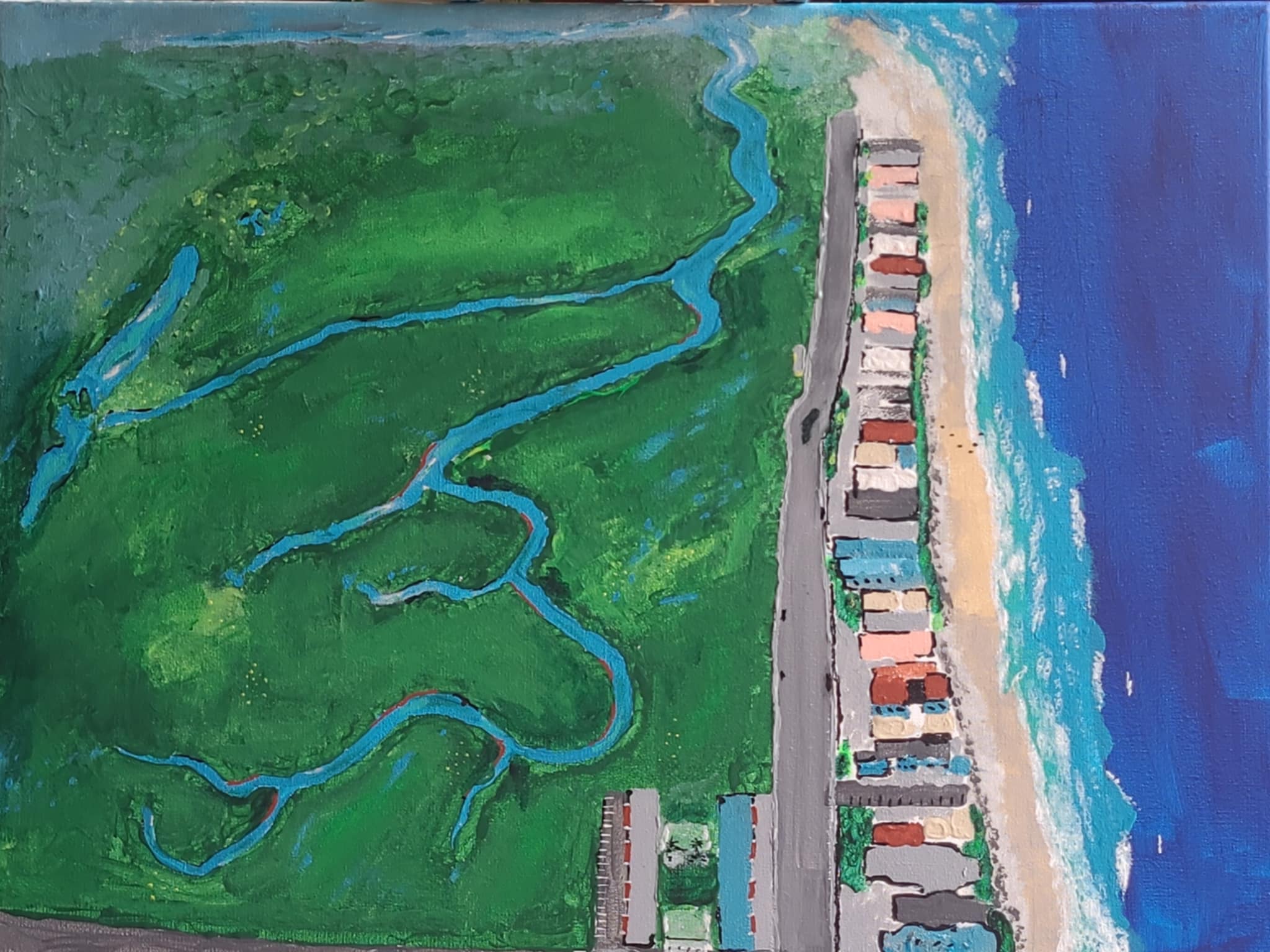 aerial view of coastline with greenway, strip of houses, sand then blue water